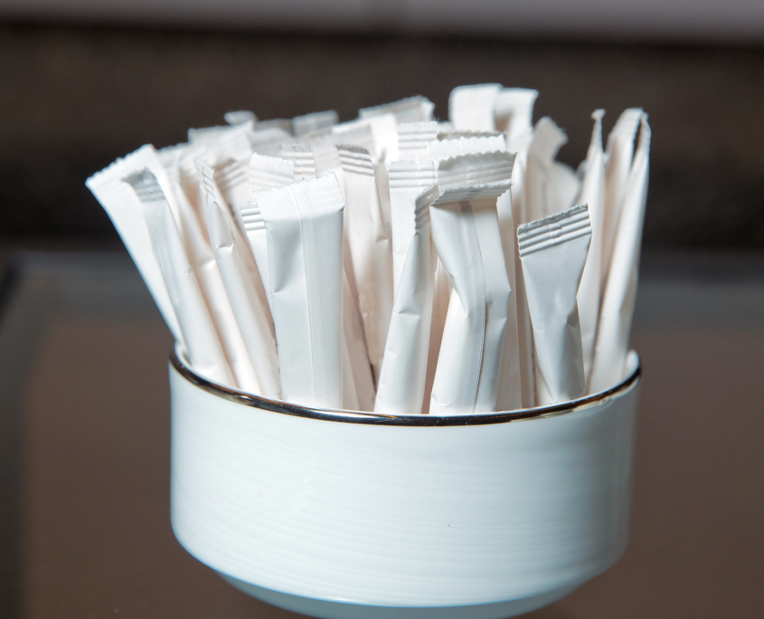 sugar packets sitting inside a small bowl