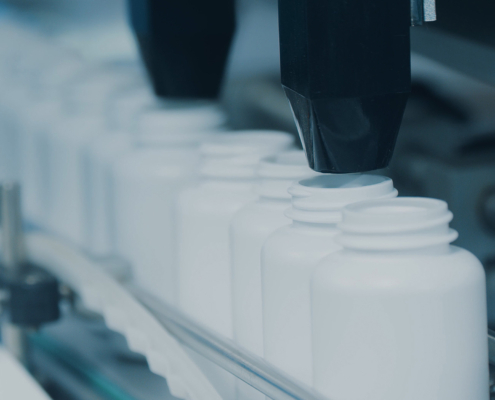 Side view of bottle filling conveyor for medicine