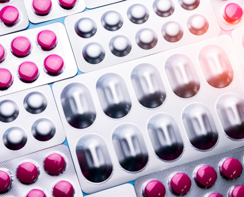 Pink tablets in blister pack and silver aluminium foil pack for capsule and tablets pills in pharmaceutical industry