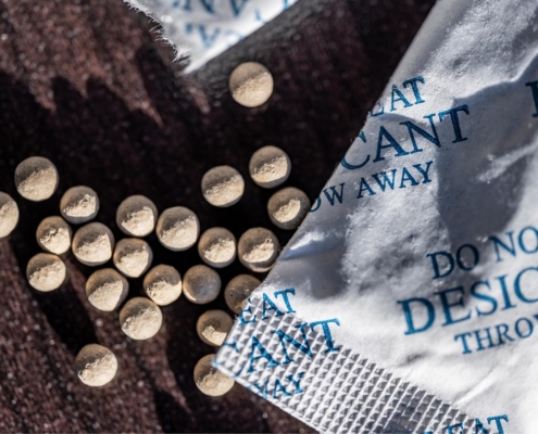 packets of desiccant scattered on a dark surface