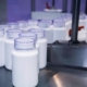 Bottles being filled in groups in factory